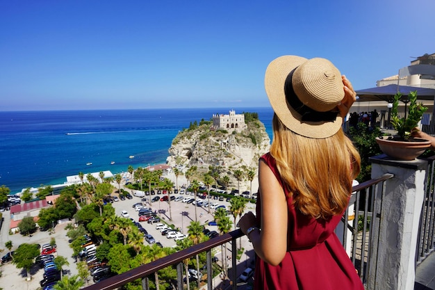 Toerisme in Italië Achteraanzicht van mooie mode meisje genieten van uitzicht op Tropea dorp aan de kust van de goden Calabrië zomervakantie in Europa