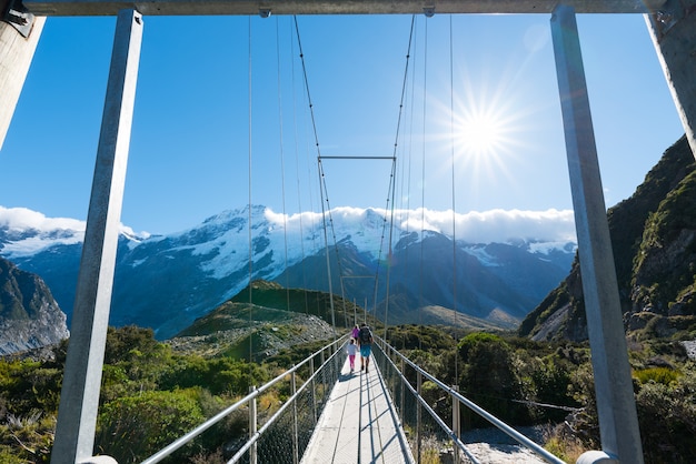 Foto toerisme lopen op de hangbrug over de rivier in nieuw-zeeland