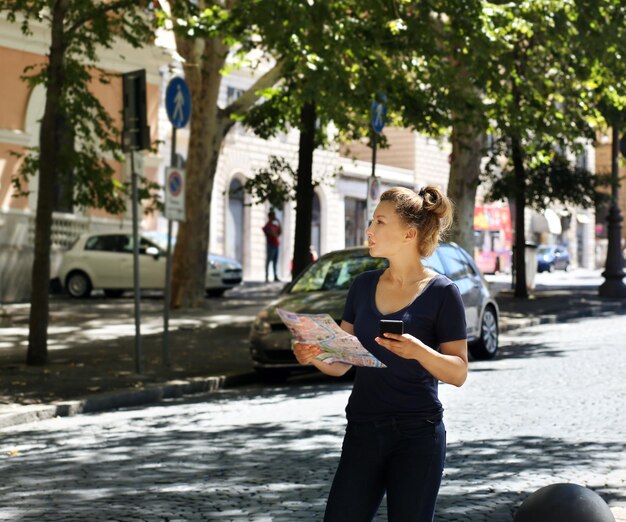 Toerist die naar een kaart kijkt. Vrouw die door de stad loopt.