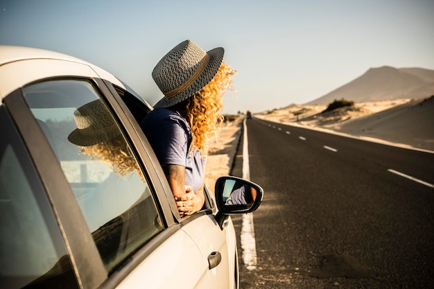 Toerist geniet van zon en buiten buiten het raam van de auto tijdens een pauze Voertuig parkeren aan de kant van de weg en vrouw mensen bewonderen landschap Concept van reizen en zomervakantie vakantie