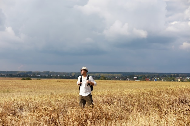 Toerist in een veld van graangewassen. Een man in een tarweveld. Graan oogst.
