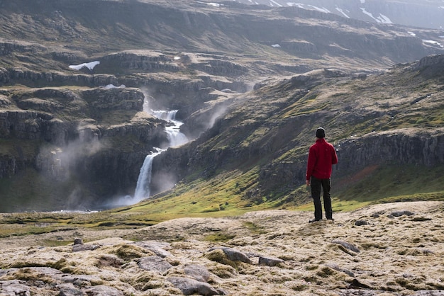 Toerist kijkt naar een waterval in IJsland