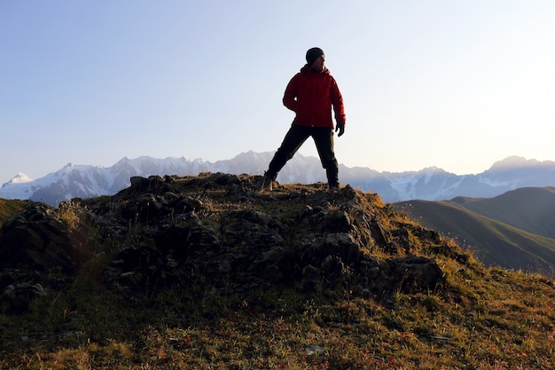 Toerist staat op een heuvel in een bergachtig gebied in georgië