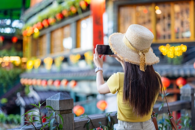 Toeriste neemt een foto op een mobiele telefoon in het dorp Jiufen in Taiwan