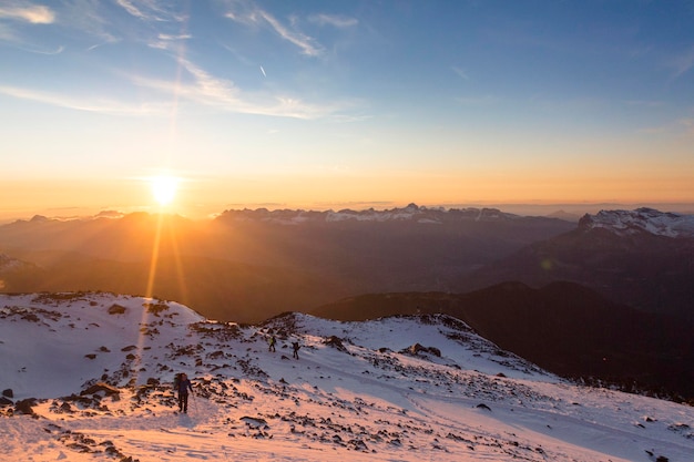 Toeristen beklimmen de berg bij de zonsondergang in de Franse Alpen