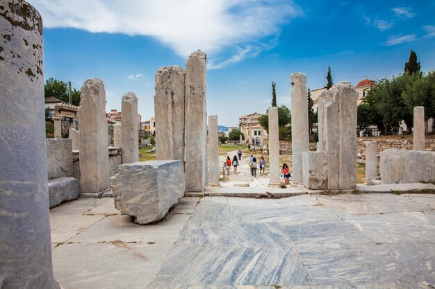 Foto toeristen bezoeken de oude ruïnes van de romeinse agora in athene