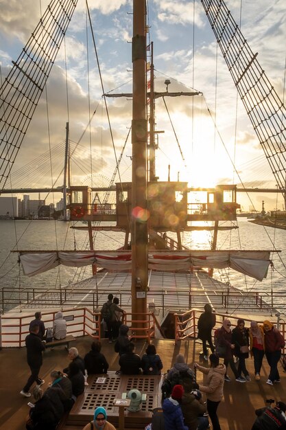 Foto toeristen die bezienswaardigheden bezoeken in het santa maria-cruiseschip bij zonsondergang osaka kansai japan 28 november 2019