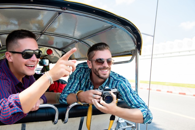 Toeristen die en pret op Tuk Tuk-taxi in Thailand hebben opgewekt zijn