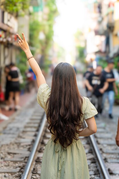 Toeristen die foto's maken van een razende trein De Hanoi Train Street is een populaire attractie Uitzicht op de trein die door een smal straatje van de oude wijk van Hanoi rijdt