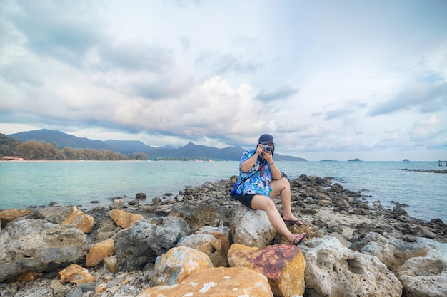 Foto toeristen maken foto's op de rotsen bij de zee van koh chang.