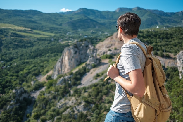 Toeristen met rugzak genieten van uitzicht op de vallei vanaf de top van een berg