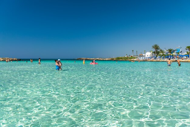 Toeristen ontspannen en zwemmen op een van de populairste stranden van het eiland.