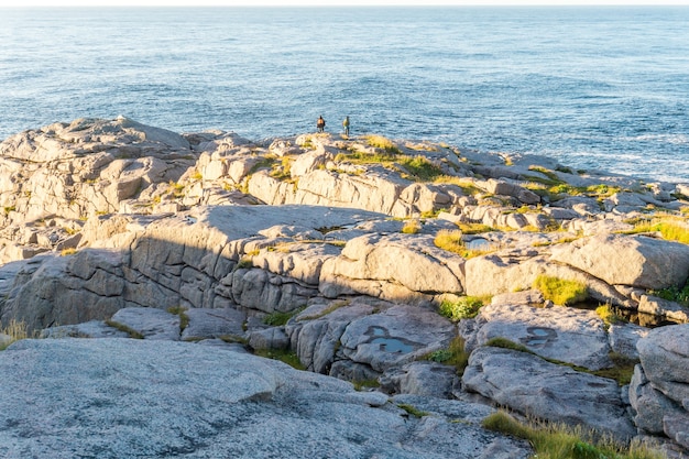 Toeristen op de rotsen aan de oevers van de Barentsz-zee, Mageroya-eiland, Noorwegen