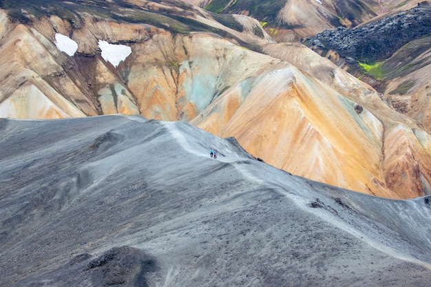 Toeristen passeren de helling van de bergroute in Landmannalaugar