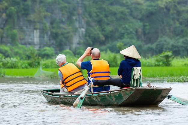 Toeristen reizen in boot langs de rivier de Ngo Dong