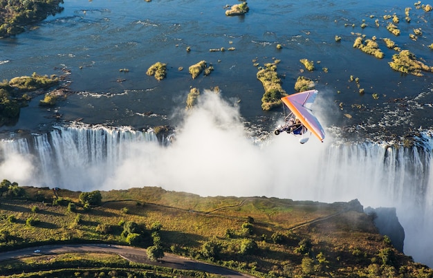 Toeristen vliegen met de trikes over de Victoria Falls. Afrika. Zambia. Victoria watervallen.