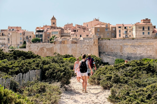 Toeristen wandelen in het natuurreservaat van bonifacio met de huizen aan de rand van de klif voor hen