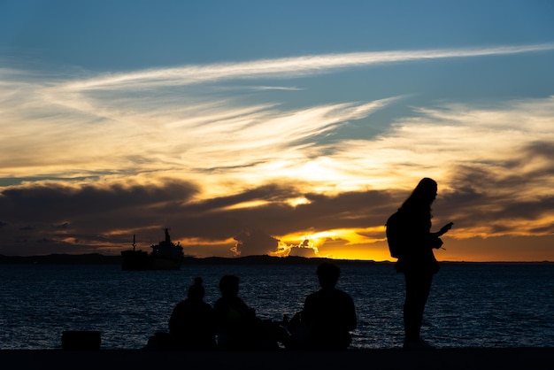 Foto toeristen worden gezien bij ponta de humaita die genieten van de dramatische zonsondergang in de stad salvador bahia