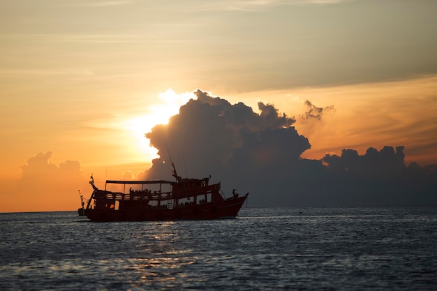 Toeristenboot die tegen mooie zonsonderganghemel vaart