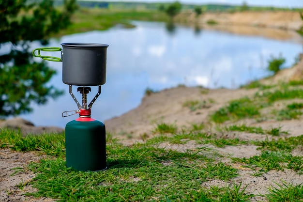 Toeristenbrander op gas met kookpot en achtergrondrivier