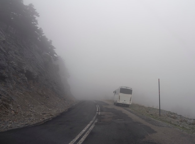 Toeristenbus naar bergweg, mist en wolken in bos in bergen Dirfys op eiland Evia, Griekenland