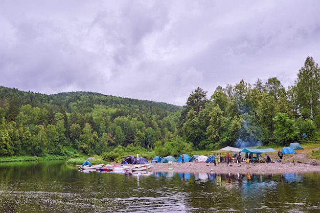 Toeristenkamp aan de rivier. Tenten onder de blauwe lucht. Raften op een bergrivier. River White Republic of Bashkiria 03.07.2019