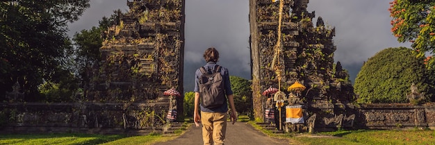 Toeristenmens die door traditionele Balinese Hindoese poort candi bentar loopt dichtbij bedugul bratan