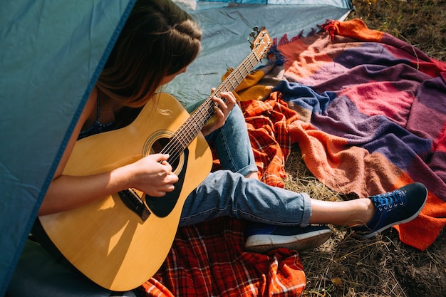 Toeristisch meisje gitaar spelen concept. toerisme rust op de natuur. camping levensstijl