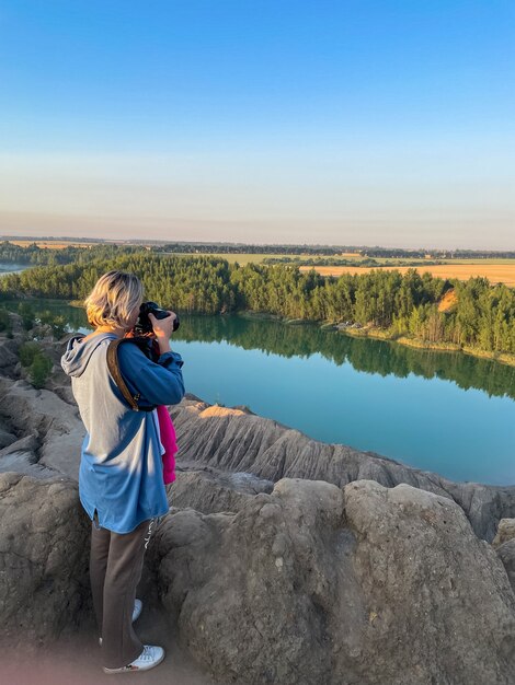 Toeristisch meisje houdt in handen neem fotografie klik op moderne fotocamera