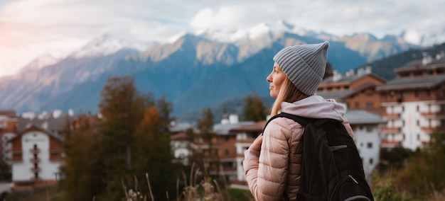 Toeristisch meisje kijkt naar een huisjesdorp in de bergen in een skiresort in Sochi op Krasnaya Polyana Een vrouw staat op zoek en kijkt voor een bergstadje Rustige landelijke plaats Rosa Khutor