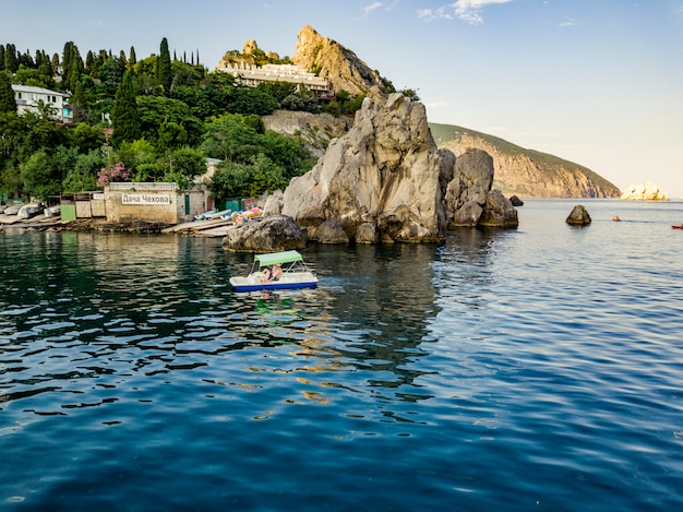 Toeristische kleine catamaran langs de rots klif kust op de zee