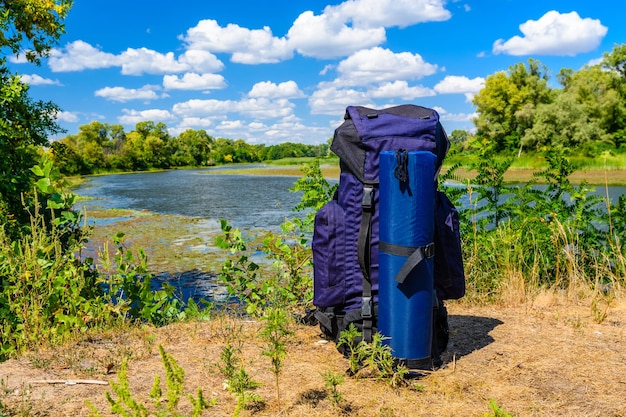 Toeristische rugzak aan een oever van de rivier