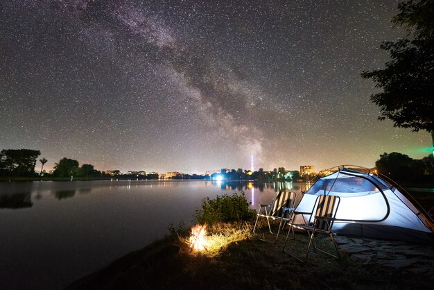 Toeristische tent en kampvuur 's nachts