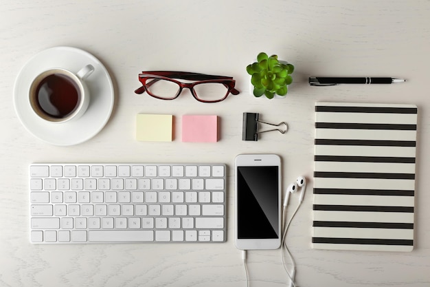 Toetsenbord telefoon notebook en kopje koffie op een houten bureau achtergrond bovenaanzicht