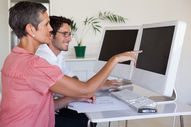 Toevallig commercieel team die bij bureau samenwerken die computer met behulp van