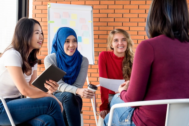 Toevallige multi-etnische vrouwen die voor sociaal project samenkomen