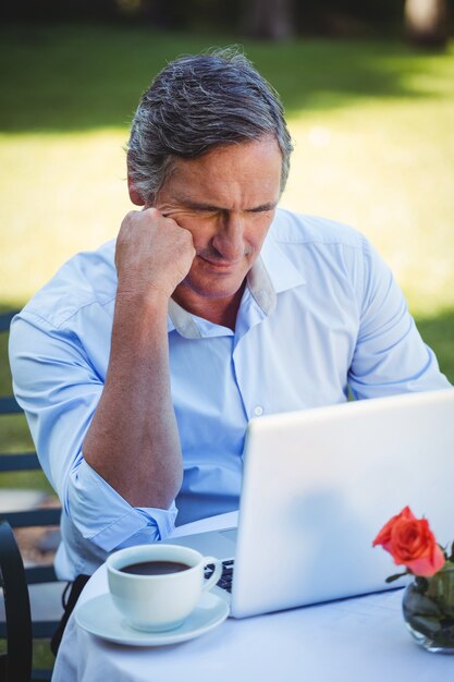 Toevallige zakenman gebruikend laptop en hebbend koffie