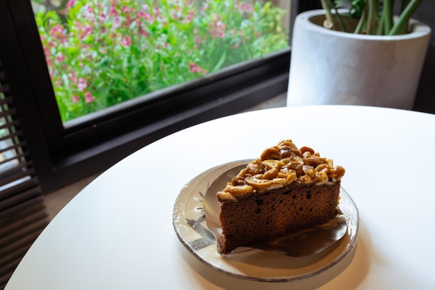 Toffee cake with cashew nut and caramel syrup on white table background Copy space