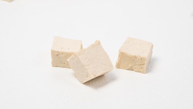 Фото Сыр тофу, изолированный на белом фоне, тофу, нарезанный на кубики и кусочки