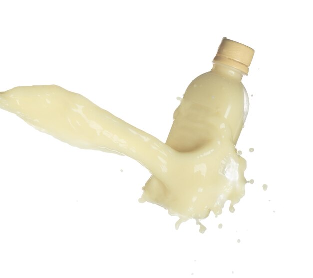 토푸 콩 콩 우유는 병 용기에 떨어집니다. 콩  또는 화장품 크림 보습제는 페인트 색상으로 어집니다. 색 배경 고속 셔터 동결 움직임으로 고립됩니다.