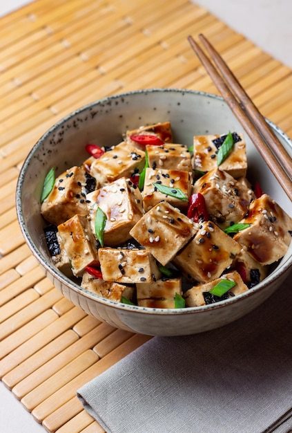 Tofu in teriyaki sauce with green onions chili peppers and
sesame asian food vegetarian food healthy eating