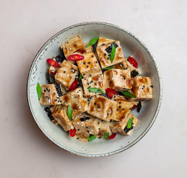 Tofu in teriyaki sauce with green onions chili peppers and sesame Asian food Vegetarian food Healthy eating