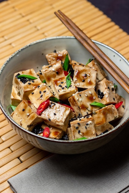 Tofu in teriyaki sauce with green onions chili peppers and
sesame asian food vegetarian food healthy eating