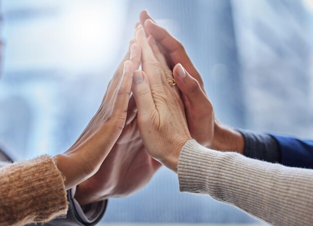 Together we can do this Shot of a group of businesspeople high fiving each other