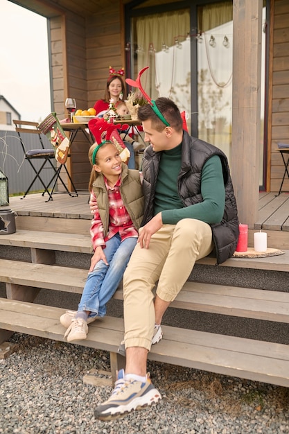 Togetherness. Dad sitting with his daughter on the steps of the house