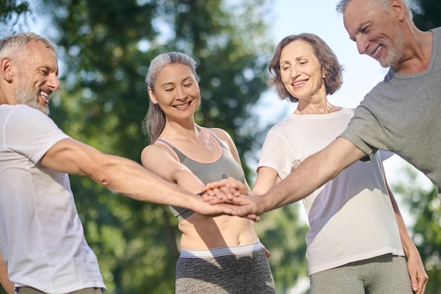 Togetherness. A group of mature people in sportswear feeling great together in the park