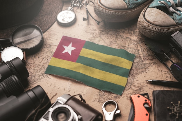 Флаг Того между аксессуарами путешественника на старой винтажной карте. Концепция туристического направления.