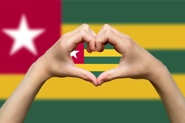 Foto bandiera del togo con due mani forma cuore patriottismo e nazionalismo idea mano cuore segno d'amore