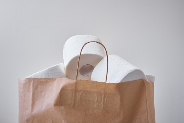 Toiketpapier rolt in een boodschappentas. Paniek kopen over coronavirus covid-19 voor thuisquarantaineconcept