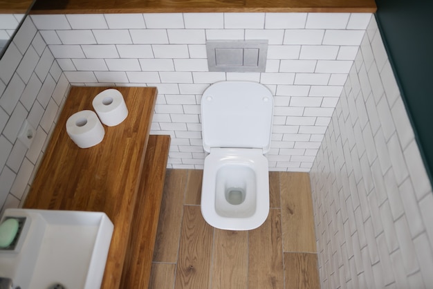 Toilet bowl stall in modern bathroom interior closeup